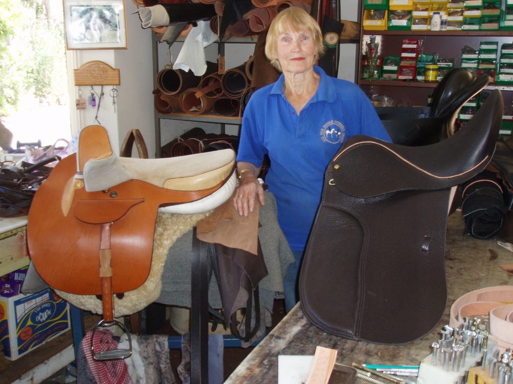 Wendy Tibold in her workshop with a tan and dark brown side saddle created from quality leather